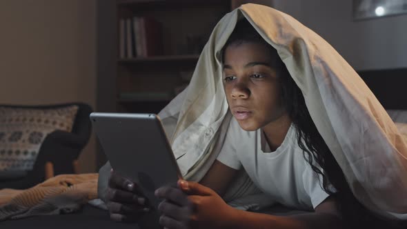 Girl Using Tablet in Bed