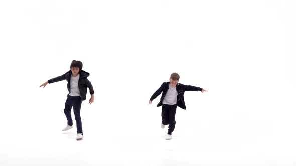 Little Boys Are Dancing a Modern Dance on the White Background in Black Leather Jackets and Jeans