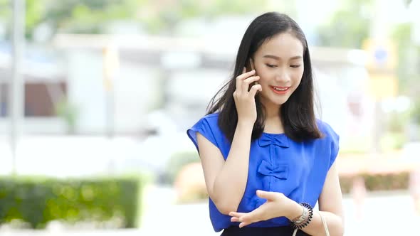 Woman talking on the phone in front of the mall