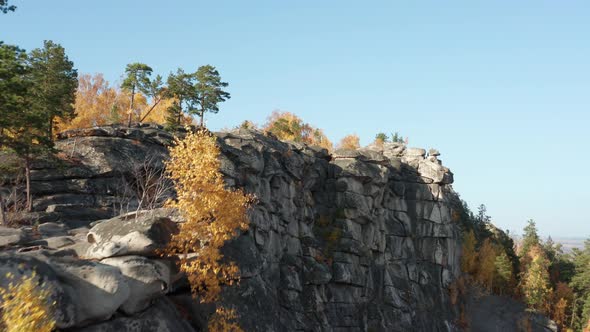 Aerial View of a Cliff Surrounded By a Colorful Autumn Forest at Sunset