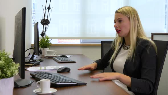 An office worker works on a computer, then gets angry