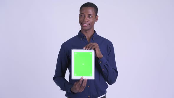 Young Happy African Businessman Thinking While Showing Digital Tablet