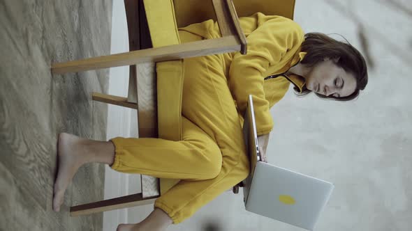 Woman in yellow using laptop computer