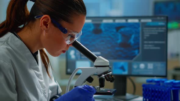 Portrait of Scientist Looking Under Microscope in Medical Lab