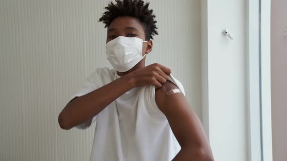 African American Teenager Showing COVID19 Vaccine Bandage Merrily