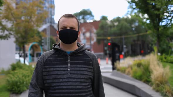 Man Wearing Mask Walking Across City