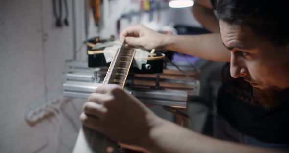 Luthier Measures the Fretboard Angle of the Electrick Guitar Neck on the Jig Repairing the Musical