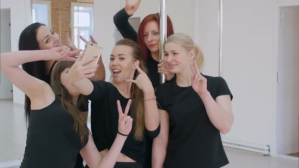 Group of Beautiful Young Women Taking a Selfie with Smartphone During a Pole Dance Class