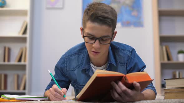 Diligent Teenage Student in Glasses Preparing to Exams in College, Deadline