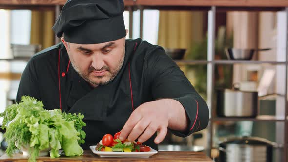 Male Chef Adding Tomato Decorating Vegetable Salad