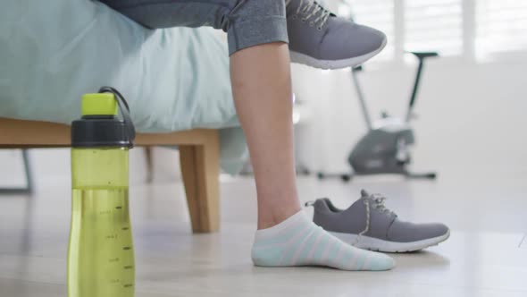 Hands of asian woman preaparing for exercise, tying shoes