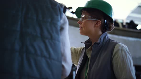 Livestock Worker Talking Colleague at Milking Production Parlour Close Up