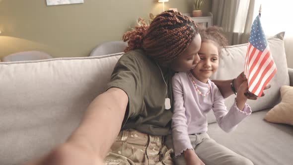 POV of Military Woman with Little Daughter Waving US Flag alt
