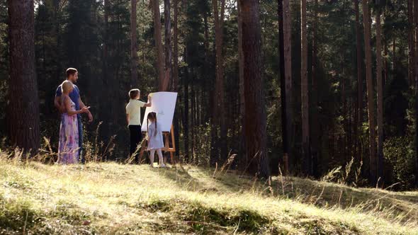 Happy Family Young Parents Drawing Coloring Picture with Brush Helping Cute Child Daughter Enjoying