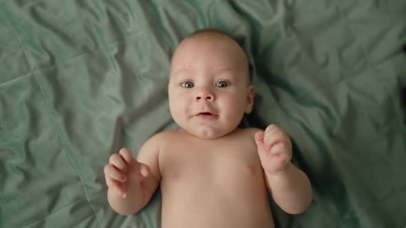 A Little Boy is Engaged in Boxing Lying on the Bed