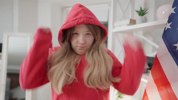 Portrait of Angry Teenage Asian Girl Putting on Hood and Gesturing