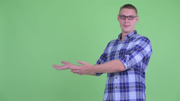 Happy Young Hipster Man Showing Something To the Back