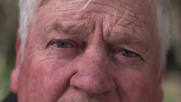 Up close view of older man shruging eyebrows.