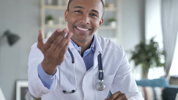 Inviting Gesture By AfricanAmerican Doctor in Clinic