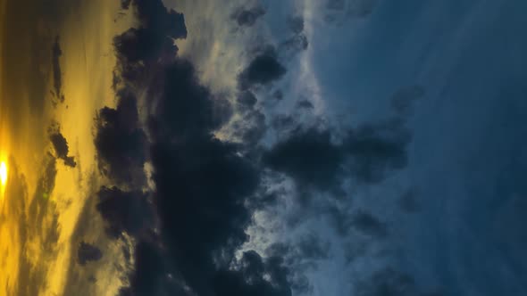 Vertical Format Video Time Lapse of Dramatic Heavy Gray Clouds at Sunset Illuminated By the Sun