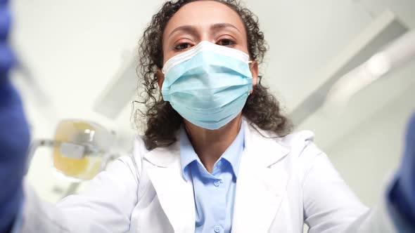 Woman Dentist Leaning Over Patient for Examination