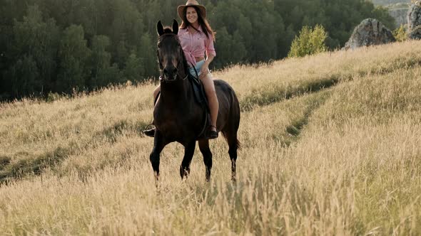 Beautiful Woman in Hat Sitting on Horseback. Young Girl Spending Outdoor Leisure Activity, Enjoying