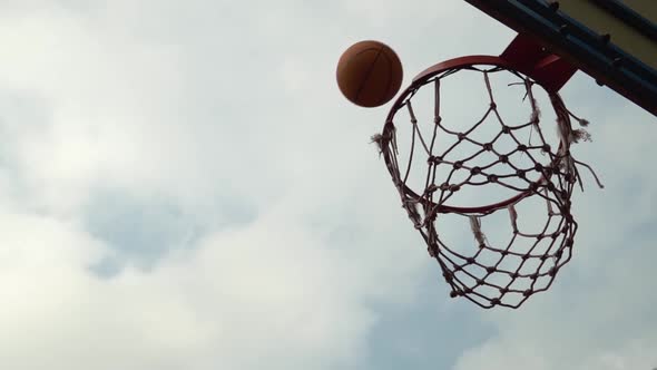Basketball Orange Ball Miss the Basket Not Hit Target in Slow Motion in Front of Cloudy Sky