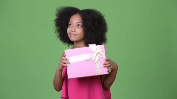 Young Cute African Girl with Afro Hair Holding Gift Box