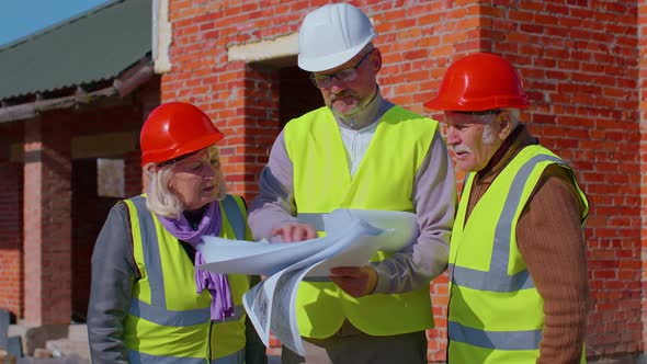 Real Estate Agent Selling New House to Senior Grandmother Grandfather Showing Building Blueprints