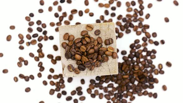 coffee grains on wooden box on white table