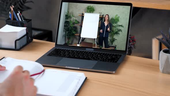 Man in Office Study Online Video Call Laptop Writes in Notebook Listen Teacher