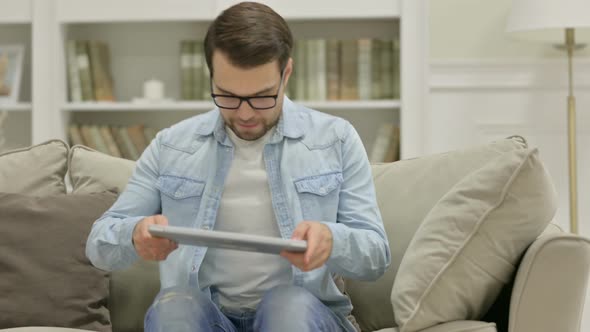 Young Man Coming Back Working on Laptop at Home