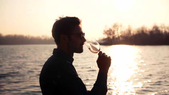 Man Drinking White Wine On Holidays Vacation. Romantic Evening Enjoying Wineglass.