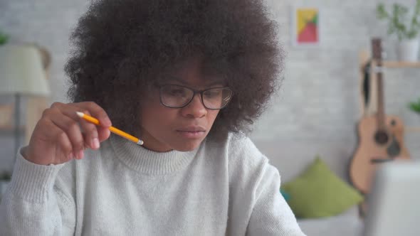 Portrait African American Woman with an Afro Hairstyle with Pencil in Hand