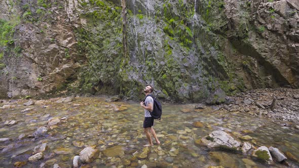 Free man standing barefoot in the creek.