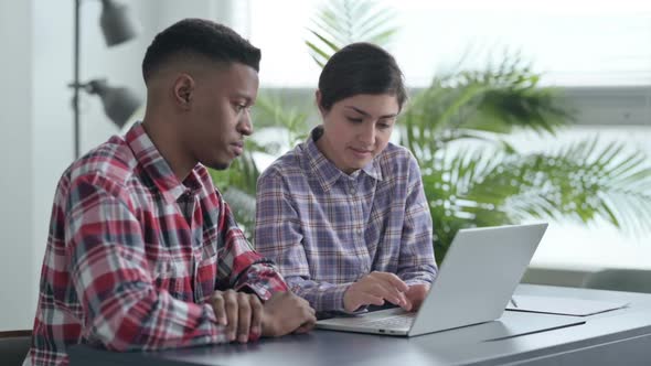 African Man and Indian Woman Working on Laptop