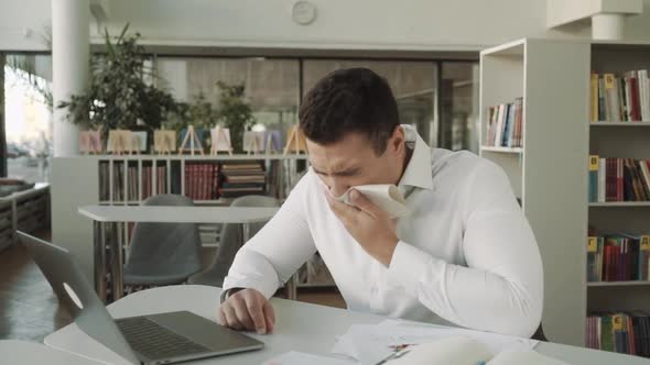 Sick Businessman with Temperature Works in Office and Wipes His Nose with a Napkin Latinos Man