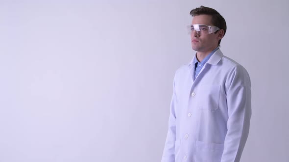 Profile View of Young Handsome Man Doctor Wearing Protective Glasses with Arms Crossed