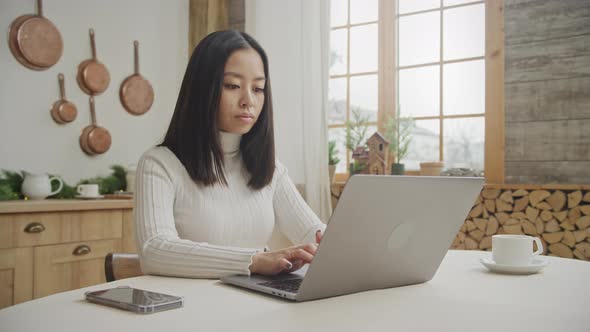 Young Adult Woman Working Focused on Her Laptop Indoors