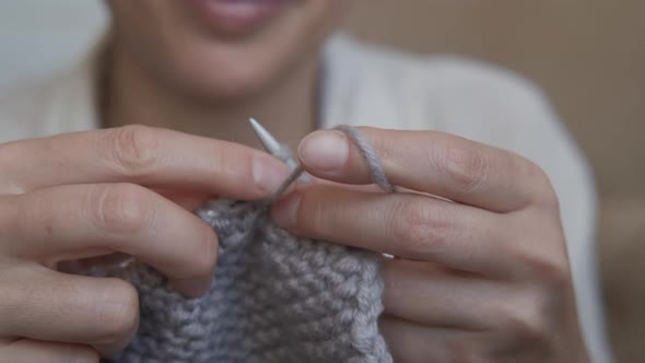 Woman knit a scarf. 