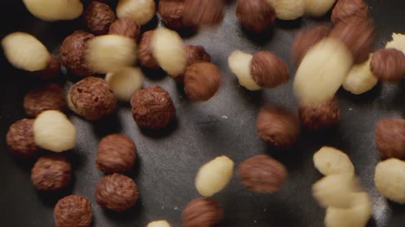 Brown Choco Cereal Balls Falling Into a Bowl Close Up