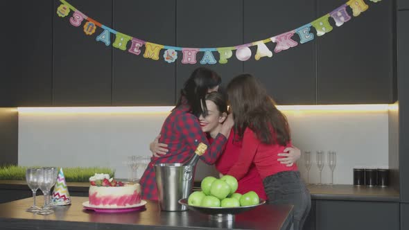 Cheerful Women Embracing, Kissing at Birthday Party