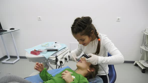 Two girls playing with dental instruments