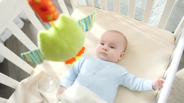 POV of Shaking Toy and Looking at Little Baby Boy Lying in Cradle at Bedroom