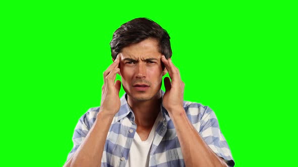 Front view of Caucasian man with headache and green screen