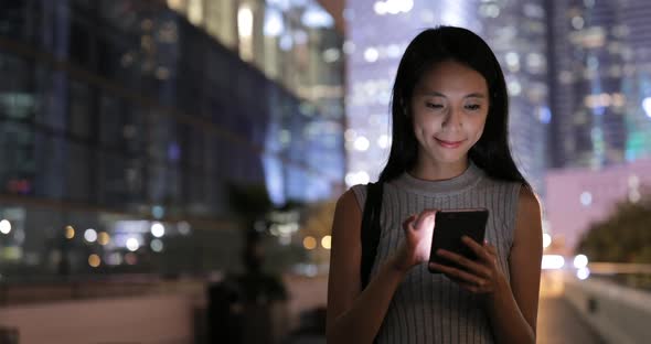 Woman looking at mobile phone in the city