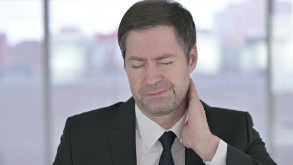 Portrait of Tired Middle Aged Businessman Having Neck Pain