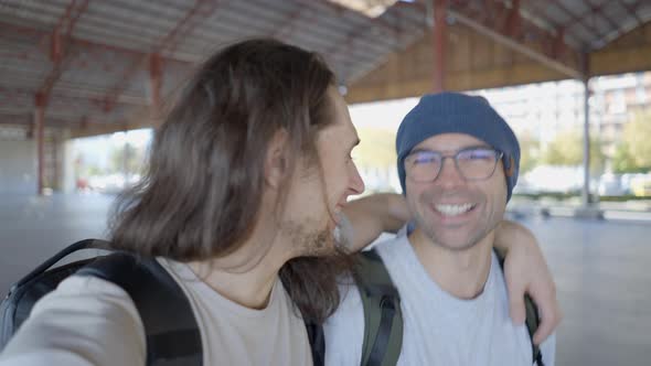 Two Happy Young Men Walk Talk and Laugh with Camera in Selfie Mode