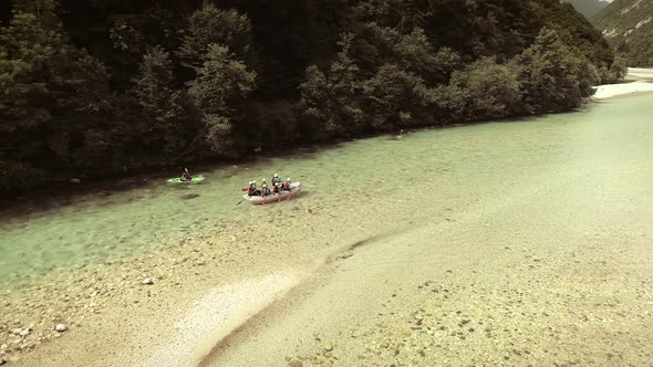 Aerial view of adventurers doing rafting and going down the Soca River.