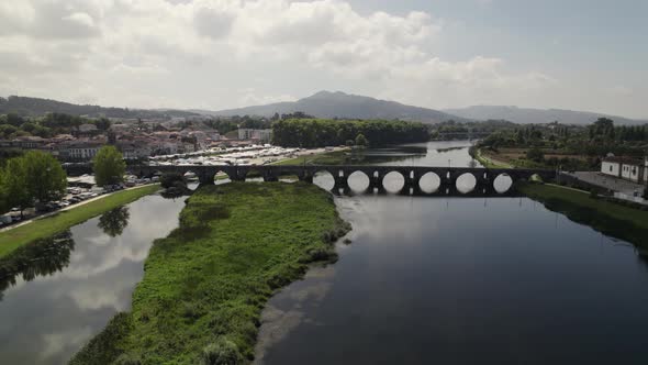 Medieval many-arched stone bridge over Lima river, Ponte de Lima; drone pan